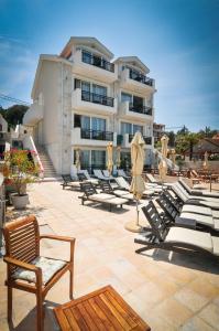 a group of chairs and umbrellas on a patio at Apartments Zukovac in Tivat