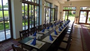 een eetkamer met een lange tafel met blauwe servetten bij Penzion Fousek in Zvíkovské Podhradí