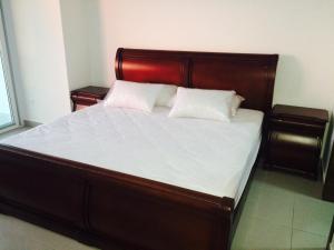 1 cama con cabecero de madera y 2 almohadas blancas en Suite frente al mar, en Tonsupa