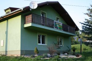 ein grünes Haus mit einem Balkon an der Seite in der Unterkunft Dolinka Holiday Home in Levoča