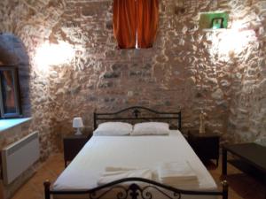1 dormitorio con cama y pared de piedra en Traditional Guest house Chrisyis, en Pyrgi