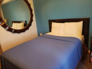 a bedroom with a bed with a mirror on the wall at Ramada by Wyndham Williston in Williston +22 photos