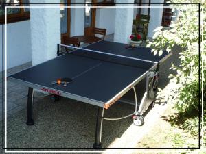 a ping pong table in front of a house at La Vieille Ferme in Étupes