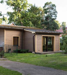 a house with a window and a yard at Vecbulduri Apartment Jurmala in Jūrmala