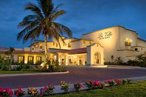a building with a palm tree in front of it at Las Villas Hotel & Golf By Estrella del Mar in Mazatlán