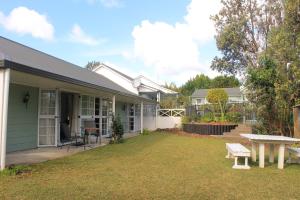 a house with a picnic table in the yard at Ash Grove Boutique Motel in Paihia