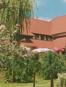 a building with a tree in front of a building at Zajazd Kosynier in Węgrzce