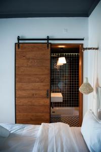 a bedroom with a wooden door with a bathroombehind it at Lemon Tree Stay in Faro