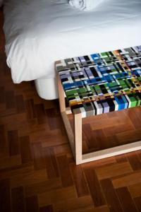 a bed with a colorful blanket on a wooden floor at Lemon Tree Stay in Faro