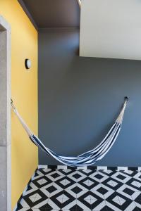 a hammock in a room with a black and white floor at Lemon Tree Stay in Faro