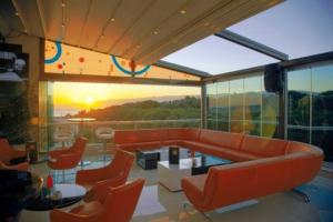 a living room with an orange couch and chairs at Idahan Hotel in Burhaniye