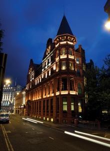 un grand bâtiment avec une tour dans une rue la nuit dans l'établissement Quebecs, à Leeds