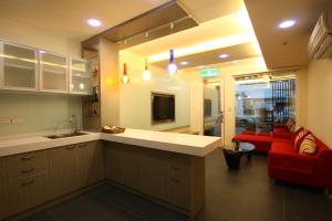 a kitchen and living room with a red couch at OS Homestay in Nanwan