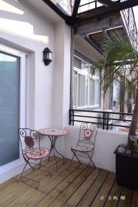 eine Terrasse mit 2 Stühlen und einem Tisch auf dem Balkon in der Unterkunft OS Homestay in Nanwan