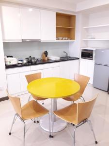 a yellow table and chairs in a kitchen at Bluesky Serviced Apartment Airport Plaza in Ho Chi Minh City