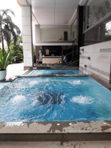 a dolphin swimming in a pool in front of a building at Bluesky Serviced Apartment Airport Plaza in Ho Chi Minh City