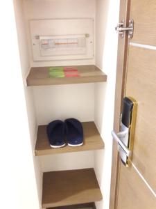 a small closet with wooden shelves and a door at Bluesky Serviced Apartment Airport Plaza in Ho Chi Minh City