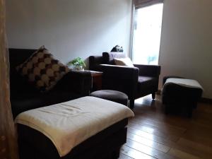 a living room with two couches and chairs and a window at Bluesky Serviced Apartment Airport Plaza in Ho Chi Minh City