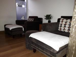 a living room with a couch and a chair at Bluesky Serviced Apartment Airport Plaza in Ho Chi Minh City