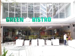 a woman standing in front of a green britino store at Bluesky Serviced Apartment Airport Plaza in Ho Chi Minh City