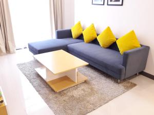 a blue couch with yellow pillows in a living room at Bluesky Serviced Apartment Airport Plaza in Ho Chi Minh City