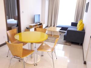 Bluesky Serviced Apartment Airport Plaza في مدينة هوشي منه: غرفة معيشة مع طاولة وكراسي صفراء