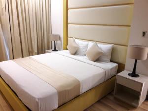 Bluesky Serviced Apartment Airport Plaza في مدينة هوشي منه: غرفة نوم بسرير ذو شراشف ووسائد بيضاء