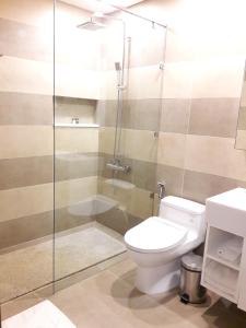 a bathroom with a toilet and a glass shower at Bluesky Serviced Apartment Airport Plaza in Ho Chi Minh City