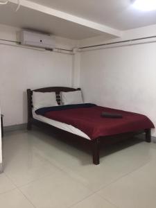 a bedroom with a bed with a red blanket on it at Alsana Hotel in Bangkok