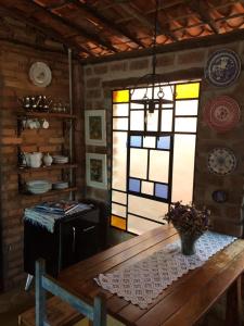 a dining room with a table and a window at hostelvi guesthouse in Lençóis