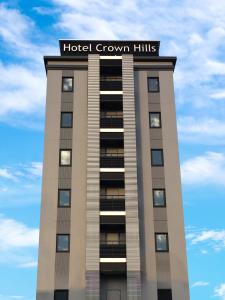 a hotel building with a sign on top of it at Hotel Crown Hills Iwaki in Iwaki