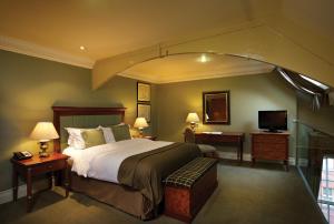 a bedroom with a large bed and a television at Quebecs in Leeds