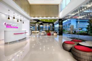 a lobby with tables and stools in a building at favehotel Tuban in Tuban