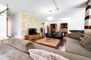a living room with two couches and a television at Appartement Ski In by A-Appartments in Brand