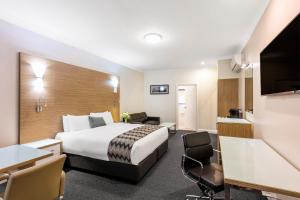 a hotel room with a bed and a desk at Mercure Goulburn in Goulburn