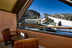 a balcony with a table and chairs and a large window at Zephyr Mountain Lodge in Winter Park