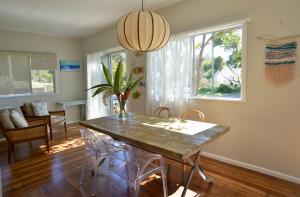 Un comedor con mesa y sillas de madera. en Tallowood beachfront cottage, en Bonny Hills 11 fotos más