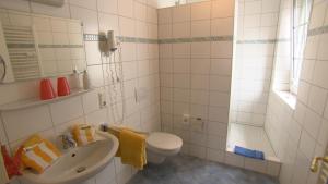 a white bathroom with a toilet and a sink at Hotel Gästehaus Priester in Limburg an der Lahn