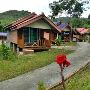 a house with a red flower in front of it at Phusam Big Resort in Koh Mook