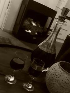 a bottle of wine and two glasses on a table at Blarney Stone Cottage in Killarney