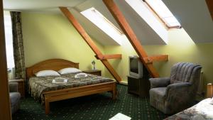 a bedroom with a bed and a tv and skylights at Hotel Tukums in Tukums