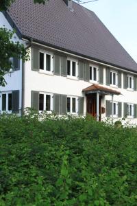 une maison blanche avec un toit noir dans l'établissement BB Baischhof Barabein, à Warthausen