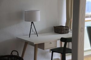 een bureau met een lamp en een stoel in een kamer bij BB Baischhof Barabein in Warthausen
