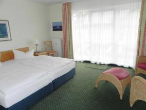 アールベックにあるFerienwohnung 1 04 Inselstrandのベッドと窓が備わるホテルルーム