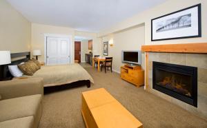 a living room with a bed and a fireplace at Fraser Crossing and Founders Pointe in Winter Park