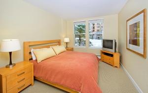 1 dormitorio con 1 cama y TV en Fraser Crossing and Founders Pointe en Winter Park