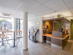 un ristorante con bancone e sedie in un negozio di B&B HOTEL Mulhouse Centre a Mulhouse