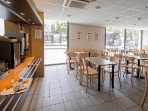 a dining room with tables and chairs in a restaurant at B&B HOTEL Mulhouse Centre in Mulhouse