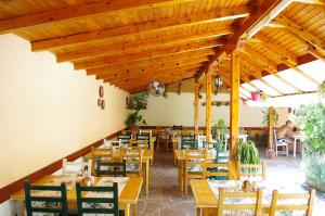un restaurante con techos de madera, mesas y sillas en Complex Diana, en Cherven