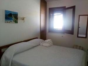 クストナーチにあるLa Casetta di Dany & Albyのベッドルーム1室(窓、タオル付)